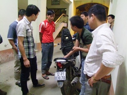 Triệt phá đường dây ma túy đưa sang Trung Quốc tiêu thụ - 1 Đối tượng Lộc Văn Cát (áo đỏ) cùng chiếc xe máy chở ma túy.