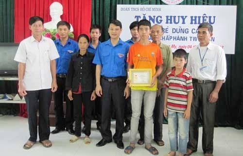 Thiếu niên cứu 2 em nhỏ nhận huy hiệu “Tuổi trẻ dũng cảm” - 1 Em Nguyễn Văn Trọng (áo cam) nhận huy hiệu Tuổi trẻ dũng cảm. (Ảnh: Báo Thái Nguyên)