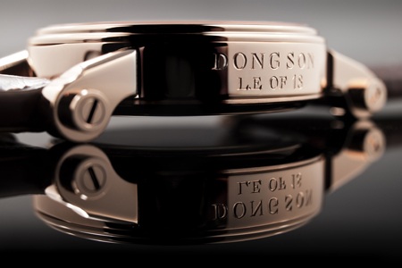 Speake Marin giao chiếc “Trống Đồng Đông Sơn” cuối cùng - 3 Dòng chữ “Dong Son Le Of 18” được khắc tay thủ công trên thân vỏ vàng hồng nguyên khối.