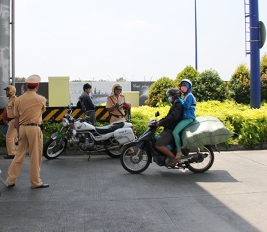 Xe máy của người thanh niên chở đầy hàng khiến người ngồi sau phải ngồi cheo leo hết sức nguy hiểm,
