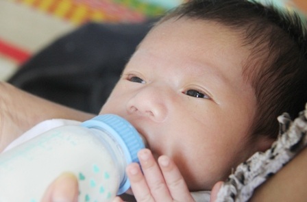 Cháu bé hạnh phúc trong vòng tay mẹ