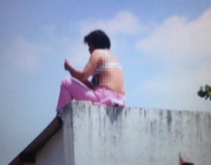 Bà V. lên nóc nhà trụ sở công an cởi áo, nằm, ngồi, la hét... gây náo loạn.