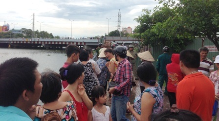 Rất đông người hiếu kỳ đứng dọc 2 bên kênh và trên cầu theo dõi vụ việc.