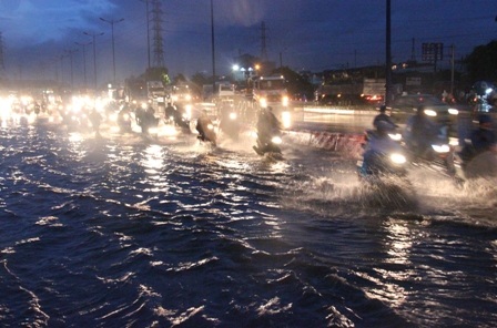 Xe máy vô cùng khó khăn vượt qua nước ngập để vào thành phố.