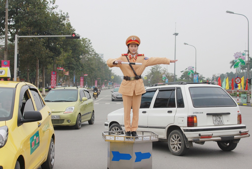 Nữ cảnh sát điều tiết giao thông tại ngã tư Quảng trường Hồ Chí Minh (TP Vinh, Nghệ An).