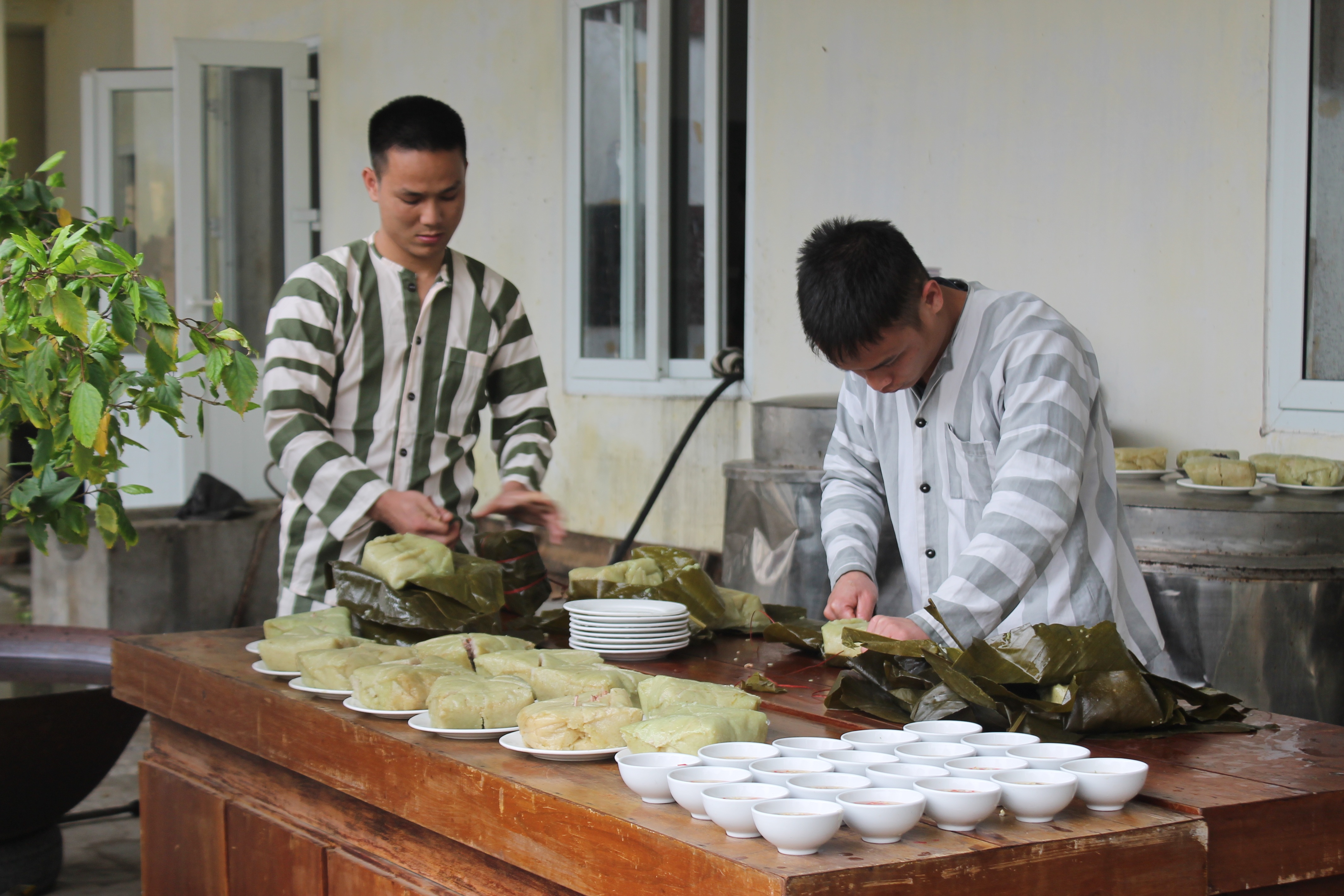 Phạm nhân Phan Văn Hoàn (bên trái) chuẩn bị cho bữa cơm tất niên với những người cùng cảnh ngộ.