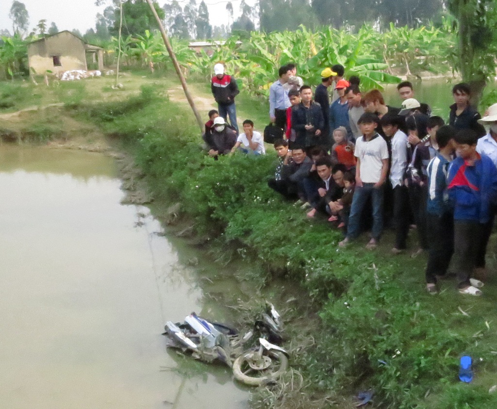 Chiếc xe máy nằm dưới ao cá trong tình trạng bị hư hỏng nặng.