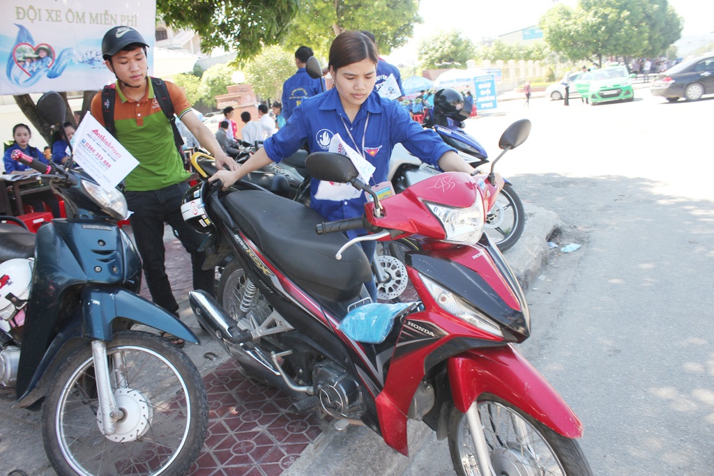 Đội nữ “xe ôm” tiếp sức mùa thi: Đã tình nguyện sợ gì ...đen da! - 2 Việc dắt xe từ vỉa hè xuống đường đối với các nữ xe ôm cũng không phải là đơn giản.