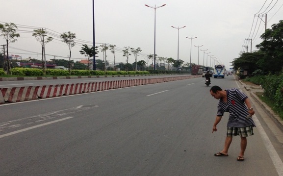 Một người dân đang chỉ lại hiện trường nơi xảy ra vụ cướp xe SH của trung úy CSGT trên Xa lộ Hà Nội