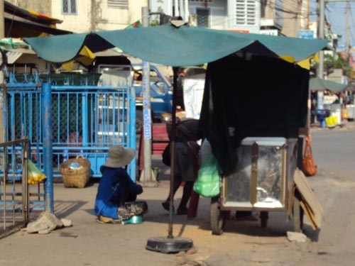 Người phụ nữ áo xanh ngồi trong mát giám sát