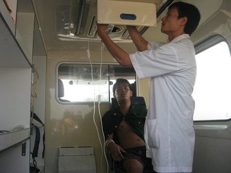 Bệnh nhân Lê Quang Minh đang được đưa lên xe cấp cứu