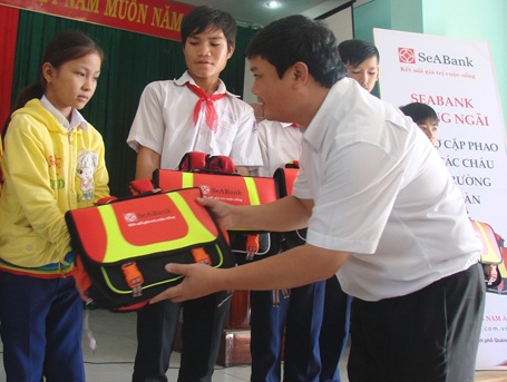 Học sinh vui mừng khi đeo chiếc cặp mới có chức năng làm phao cứu sinh. (Ảnh: Hồng Long)