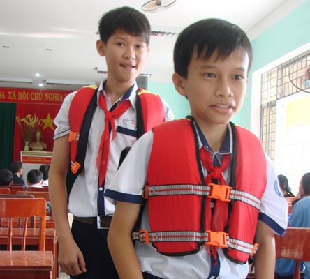 Học sinh vui mừng khi đeo chiếc cặp mới có chức năng làm phao cứu sinh. (Ảnh: Hồng Long)