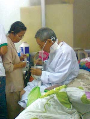 GS Phạm Phụ đang được vợ, bà Bích Hà, chăm sóc ở bệnh viện Ung bướu. (