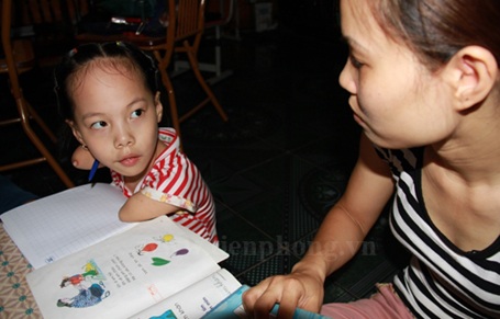 Ngắm chữ viết của “cô bé không tay” - 3 Bé Linh Chi đang học bài bên mẹ.