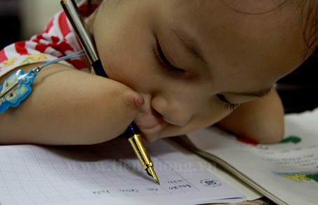 Ngắm chữ viết của “cô bé không tay” - 5 Bé Linh Chi đang học bài bên mẹ.