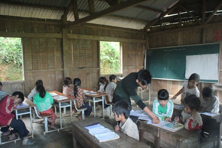 Thầy Hoàng Văn Trị uốn từng nét chữ, chỉ từng con số cho các em học sinh