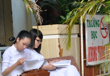 Thí sinh hoàn thành bài thi Văn - 1 Thí sinh tranh thủ ôn bài trước giờ thi. (Ảnh: Hà An)