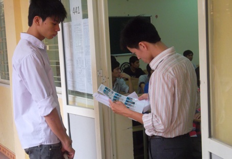 Cán bộ coi thi gọi thí sinh vào phòng làm thủ tục. (Ảnh: Thanh Luân)