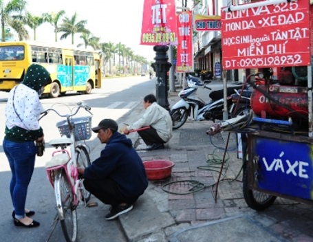 Đầu xuân, gặp người vá xe miễn phí cho học sinh - 1 Anh Trần Viết Hùng đang bơm xe cho cháu Trương Anh Thư trưa mùng bốn Tết