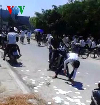 Làm rõ trách nhiệm việc thí sinh ném phao thi trắng cổng trường - 3 Nam thí sính nhặt “phao” thi sau khi bị lực lượng bảo vệ khu vực thi yêu cầu (ảnh cắt từ clip)