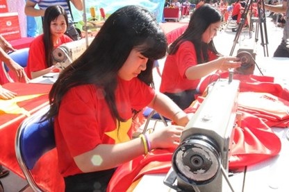 Cả trăm em học sinh tham gia may 300 lá cờ Tổ quốc. (Ảnh: GD&TĐ)