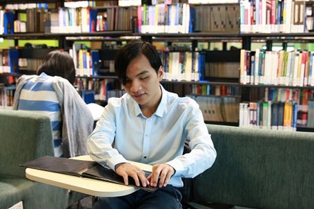 Nguyễn Thành Vinh đọc sách chữ nổi tại thư viện của trường.