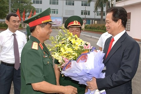 Lãnh đạo Học viện Quốc phòng tặng hoa Thủ tướng. (Ảnh: VGP/Nhật Bắc)