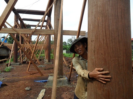 Người thợ phụ này cho biết anh phải sải hết hai cánh tay mới ôm trọn cây cột gỗ.