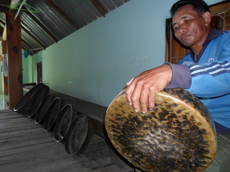 Ông Y Thon Ênuôl - trưởng buôn M’liêng - bên bộ chiêng quý hiếm của buôn.