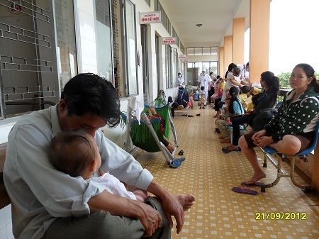 Phụ huynh ngồi, nằm la liệt trước buồng điều trị vì số phòng quá tải.