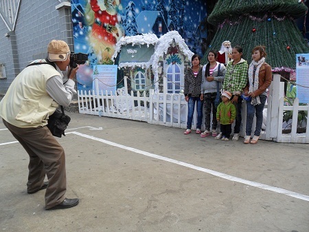 Một thợ ảnh đang chụp hình cho giới trẻ ở nhà thờ ngã 6 – TP. Buôn Ma Thuột.