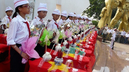 Các em học sinh dâng hoa lên các liệt sĩ.