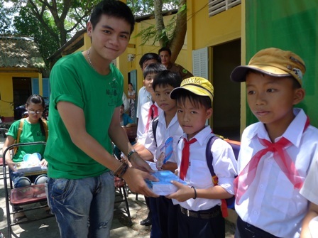 Bạn Liêm - đại diện nhóm du học sinh trao vở cho các em học sinh trường tiểu học Trường Thắng