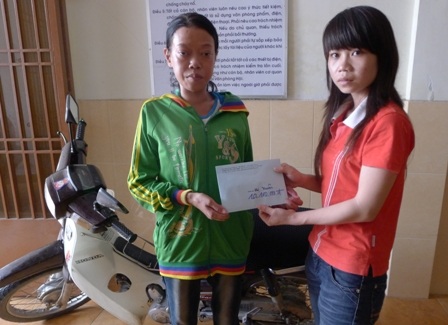 Đại diện bạn đọc PV Dân trí trao 14.100.000 đồng cho chị Thanh Xuân