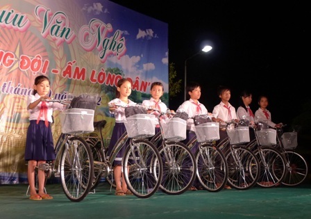 Các chiến sĩ công an huyện Thới Lai tận tình giúp các em nhận xe đạp.