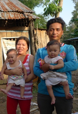 Vợ chồng anh Đồng, chị Tình đang bế hai bé Việt, Nam