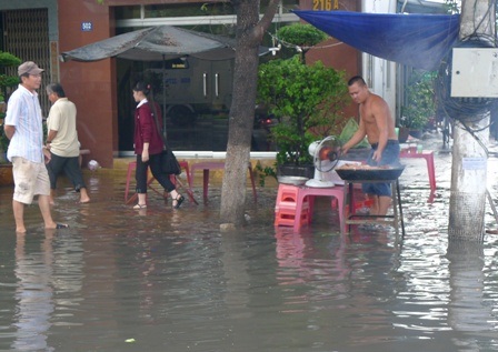 Các hàng quán lề đường vất vả chống chọi với ngập