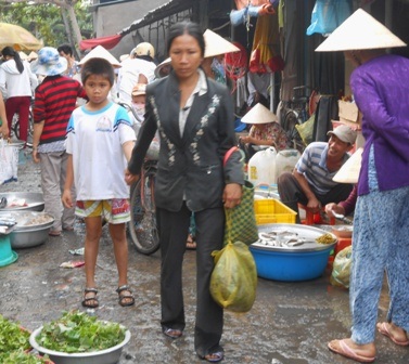 Chị Hằng cùng con trai lang thang đi bán mớ ốc vừa kiếm được