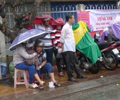 Đội mưa chờ con em.