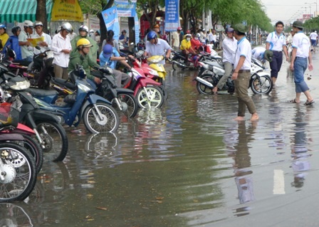 Các tình nguyện viên cũng bì bõm trong nước để giúp các phụ huynh đưa xe lên lề đường
