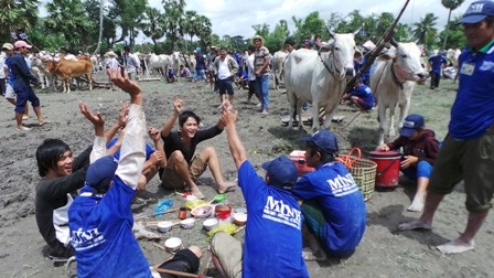 Các tài xế và khán giả không ngại ăn cơm giữa đám bùn