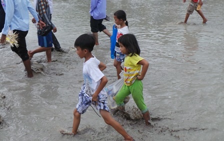 Sau cuộc đua, các em nhỏ tranh thủ đi nhặt vỏ chai, túi nilon do du khách bỏ lại