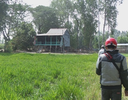 Căn nhà chị Dung đang ở và nuôi dưỡng cụ Cưng lọt thỏm ở ngoài đồng