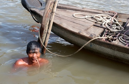Thợ lặn 1 chân đại tài ở miền Tây - 1 Chỉ cần ngậm cái ống hơi như thế này, ông Hồ Tân có thể ngâm mình dưới nước hơn 40 phút