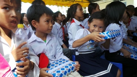 Một bé gái khoe quà với mẹ khi vừa nhận quà từ Hội Khuyến học huyện Long Mỹ