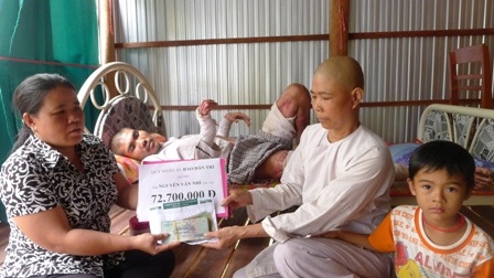 Trao hơn 72 triệu đồng đến anh Nguyễn Văn Nhí - 2 Đại diện bạn đọc Dân trí bà Nguyễn Thị Bé Bốn - Trưởng ấp Trung Sơn trao số tiền