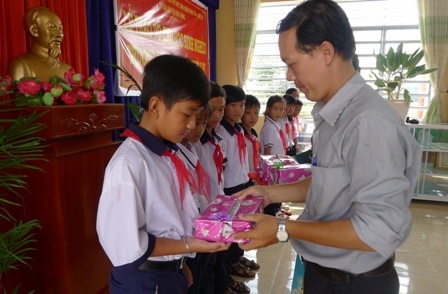 Trao 2.000 quyển vở đến học sinh nghèo huyện Thới Lai - 1 Đại diện công ty xây dựng 207 và các nhà tài trợ anh Nguyễn Văn Trường trao vở cho các em học sinh