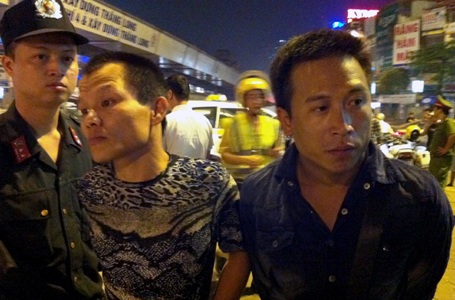 Đối tượng Bình (phải) bị cảnh sát bắt giữ.