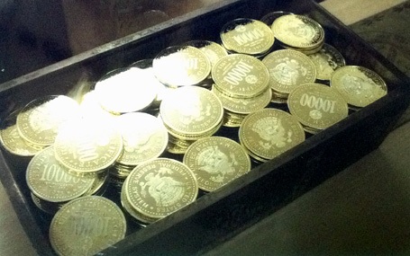 Thùng xu cổ và ảnh chụp chính diện một đồng xu cổ.